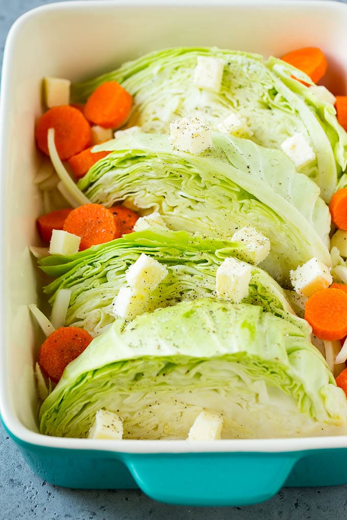 Braised Cabbage Recipe | Easy Cabbage Recipe #cabbage #lowcarb #keto #carrots #veggies #vegetarian #dinner #jonep Cabbage, carrots, onions, pieces of butter and seasonings in a baking dish.