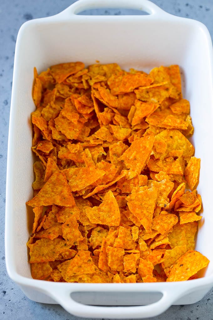 Dorito Casserole Recipe | Mexican Casserole | Beef Casserole #mexicanfood #beef #groundbeef #casserole #dinner #jonep Crushed nacho chips in the bottom of a casserole dish.