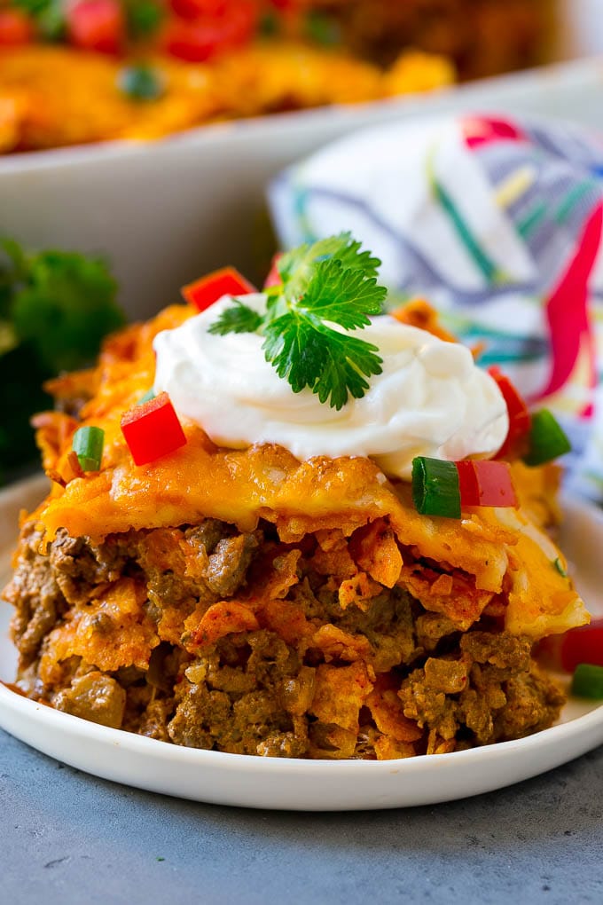 Dorito Casserole Recipe | Mexican Casserole | Beef Casserole #mexicanfood #beef #groundbeef #casserole #dinner #jonep A piece of Dorito casserole with layers of tortilla chips, beef and cheese.