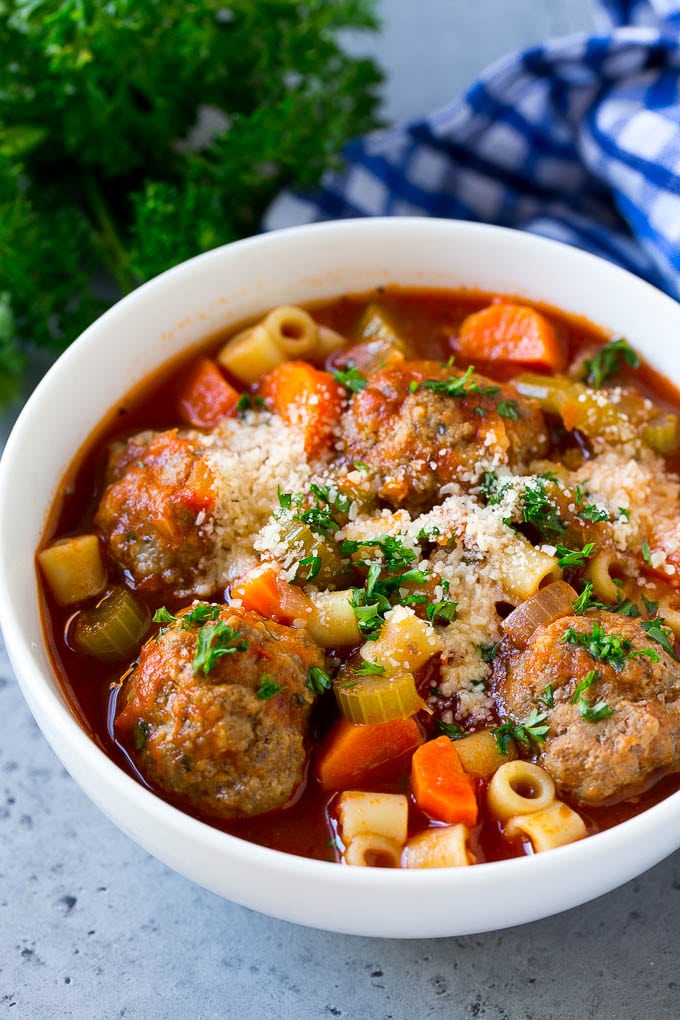 Italian Meatball Soup Recipe | Meatball Soup | Beef Meatballs #meatballs #beef #soup #italian #dinner #jonep #comfortfood A bowl of meatball soup topped with chopped parsley and grated cheese.