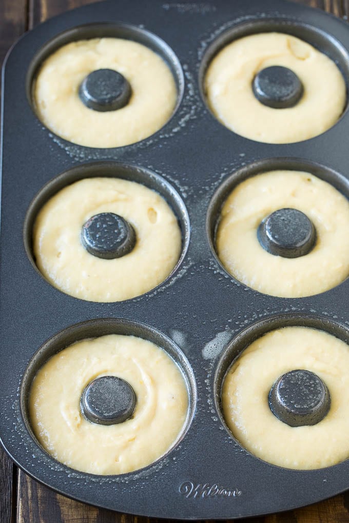 Baked Donuts Recipe | Cake Donuts | Chocolate Donuts | Sprinkle Donuts #donuts #chocolate #sprinkles #breakfast #brunch #jonep A donut pan filled with dough.