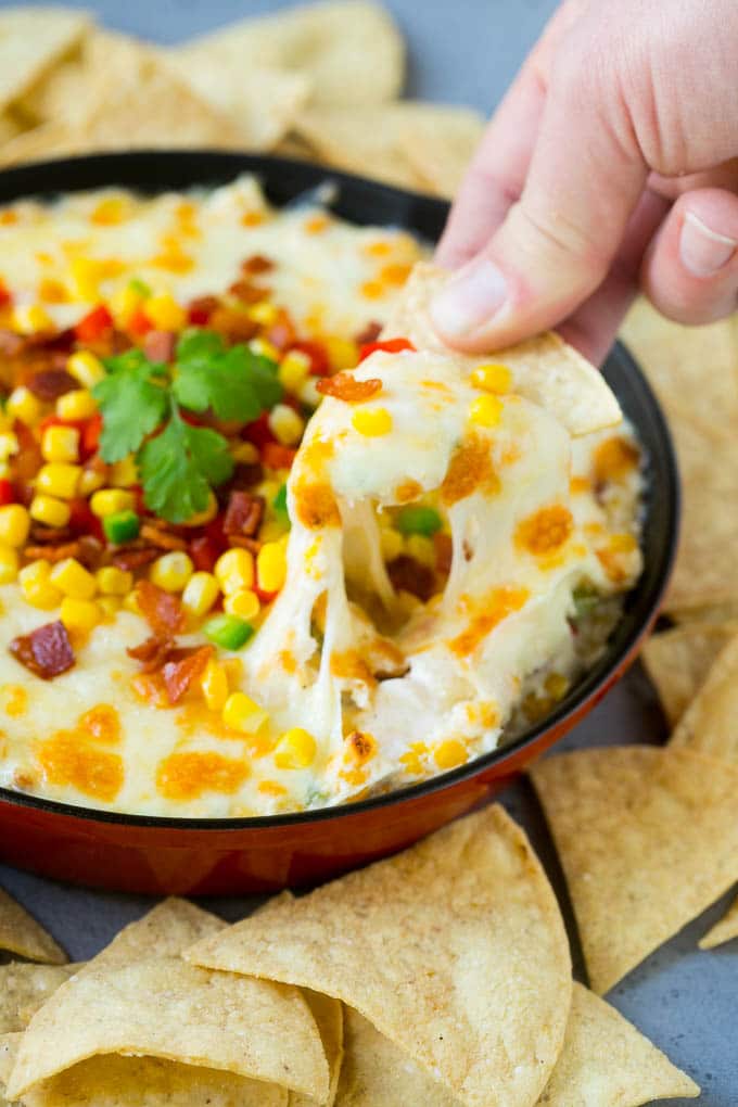 Corn Dip Recipe | Hot Cheese Dip | Bacon Dip #corn #dip #bacon #cheese #appetizer #snack #jonep A chip scooping up a serving of corn dip.