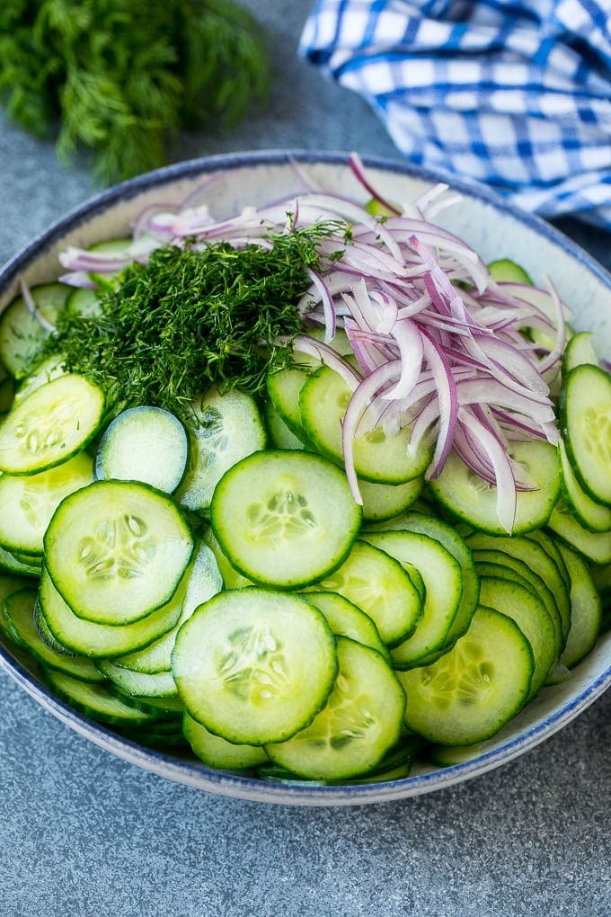 Creamy Cucumber Salad Recipe | German Cucumber Salad | Cucumber Salad #cucumber #salad #dinner #lunch #jonep #cucumbersalad Thinly sliced cucumbers, red onion and fresh dill in a mixing bowl.