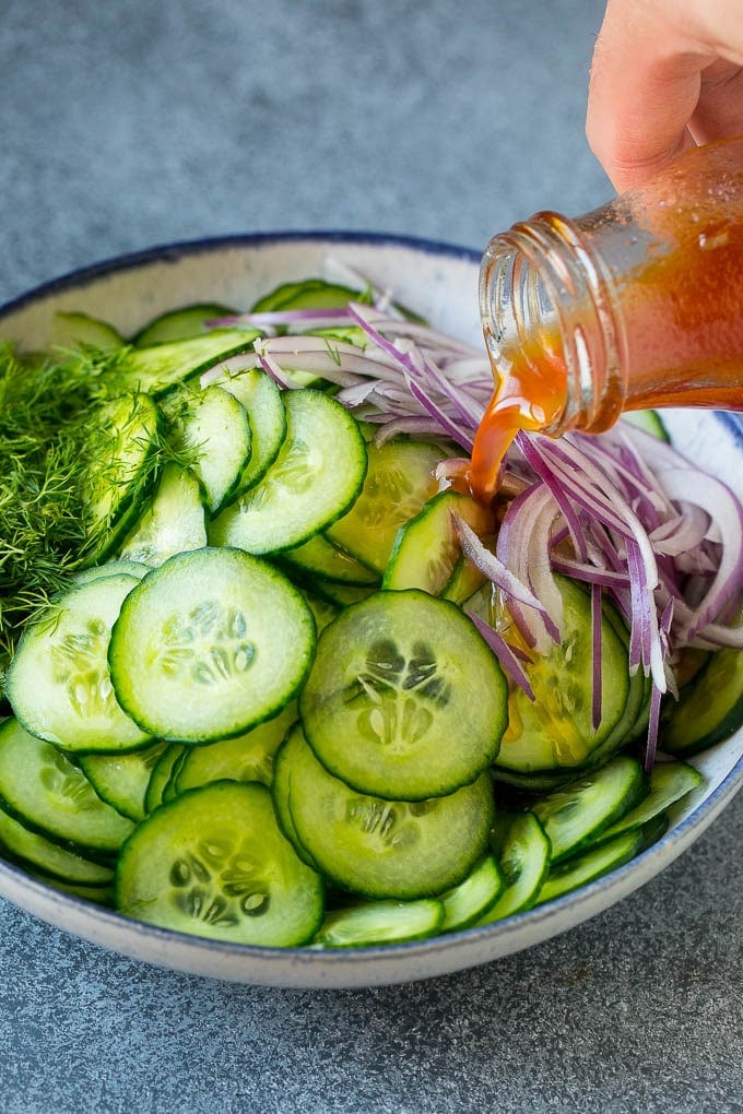 Cucumber Salad Recipe | Cucumber Dill Salad | Cucumber Recipe #cucumbers #salad #glutenfree #sidedish #jonep Dressing being poured over sliced vegetables and fresh dill.