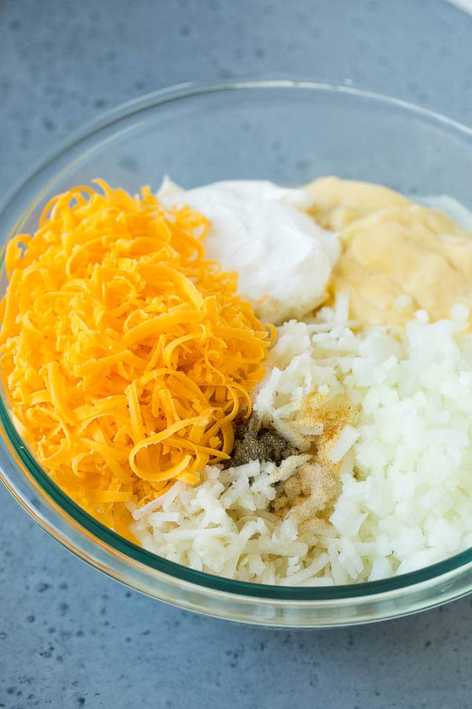 Hash Brown Casserole | Potato Casserole | Hash Brown Side Dish #potatoes #cheese #casserole #sidedish #jonep A bowl of potato shreds, cheese, cream of chicken soup, sour cream and seasonings.