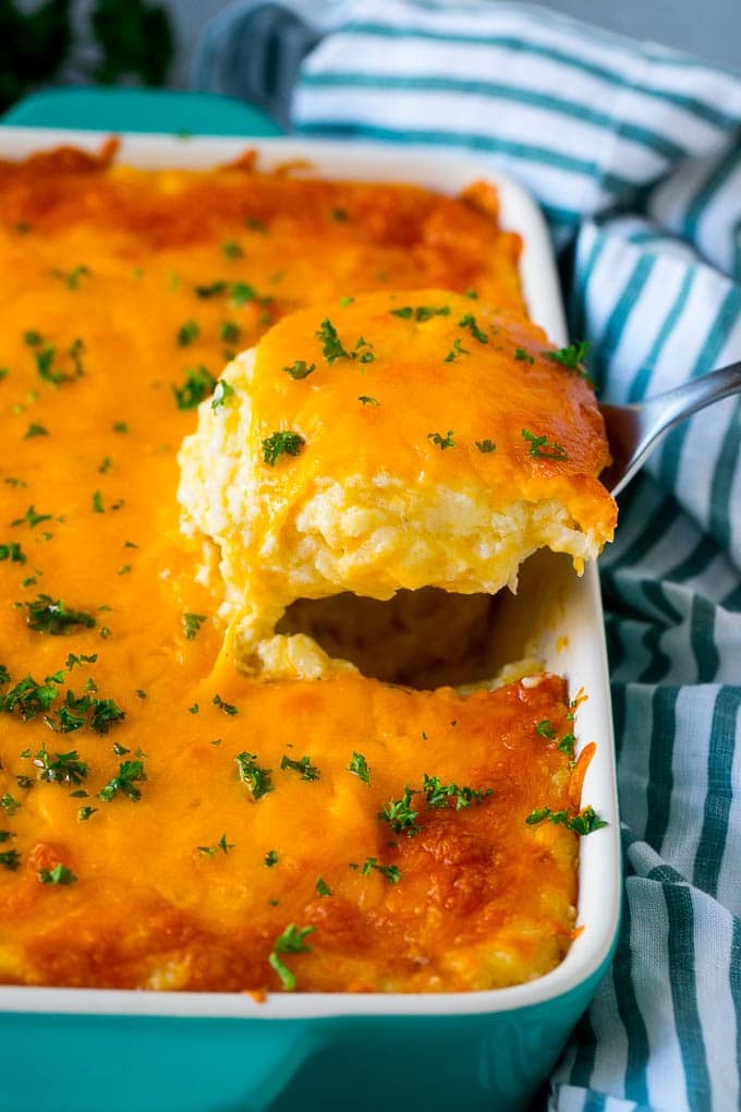 Hash Brown Casserole | Potato Casserole | Hash Brown Side Dish #potatoes #cheese #casserole #sidedish #jonep A spatula pulling out a serving of cheesy hash brown casserole.
