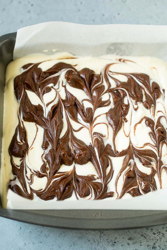 Cheesecake Brownies Recipe | Cream Cheese Brownies | Homemade Brownies #brownies #cheesecake #chocolate #dessert #jonep Swirled chocolate and cream cheese brownie batters in a baking pan.