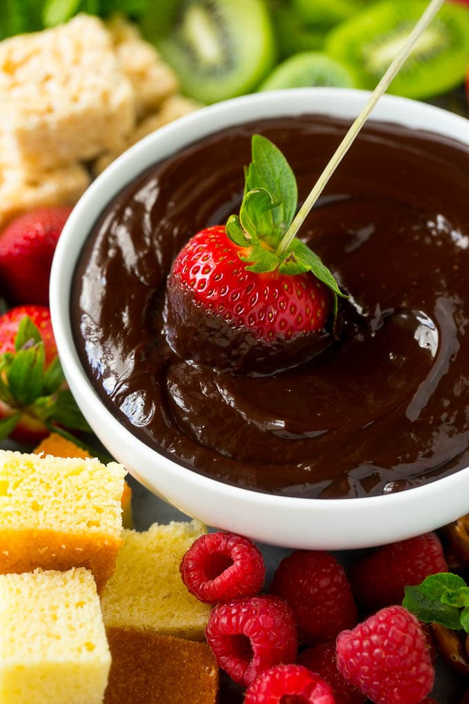 Chocolate Fondue Recipe | Chocolate Sauce | Chocolate Dip #chocolate #dessert #glutenfree #fondue #jonep A strawberry on a skewer dipped into a bowl of chocolate fondue.
