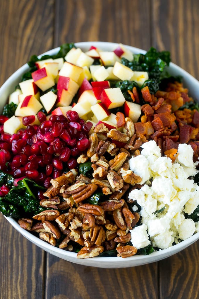 Apple Kale Salad Recipe | Kale Recipe | Fall Salad #kale #apples #bacon #salad #feta #dinner #lunch #jonep Kale salad topped with apples, bacon, pecans, pomegranate and feta cheese.
