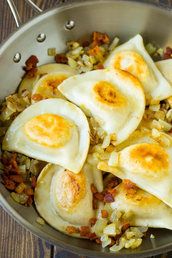 Pierogi Casserole Recipe | Potato Casserole #pierogis #casserole #bacon #cheddar #dinner #jonep Sauteed pierogis with bacon and onions in a skillet.