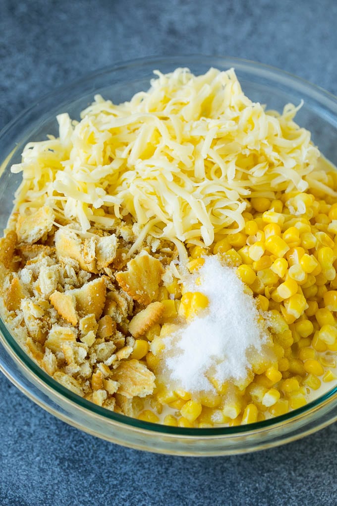 Scalloped Corn | Corn Casserole #corn #casserole #cheese #sidedish #dinner #jonep Corn, crushed crackers, seasonings and shredded cheese in a bowl.