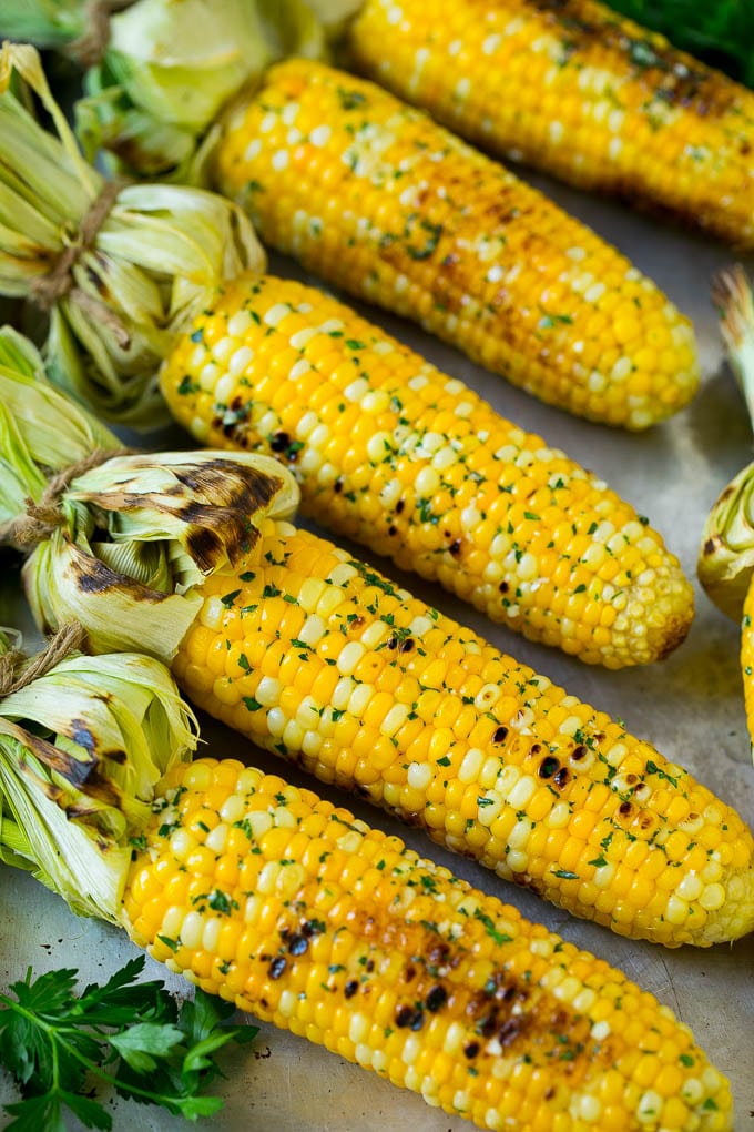 Grilled Corn on the Cob Recipe | Corn Recipe #corn #grilling #summer #sidedish #dinner #jonep Grilled corn on the cob topped with garlic and herb butter on a sheet pan.