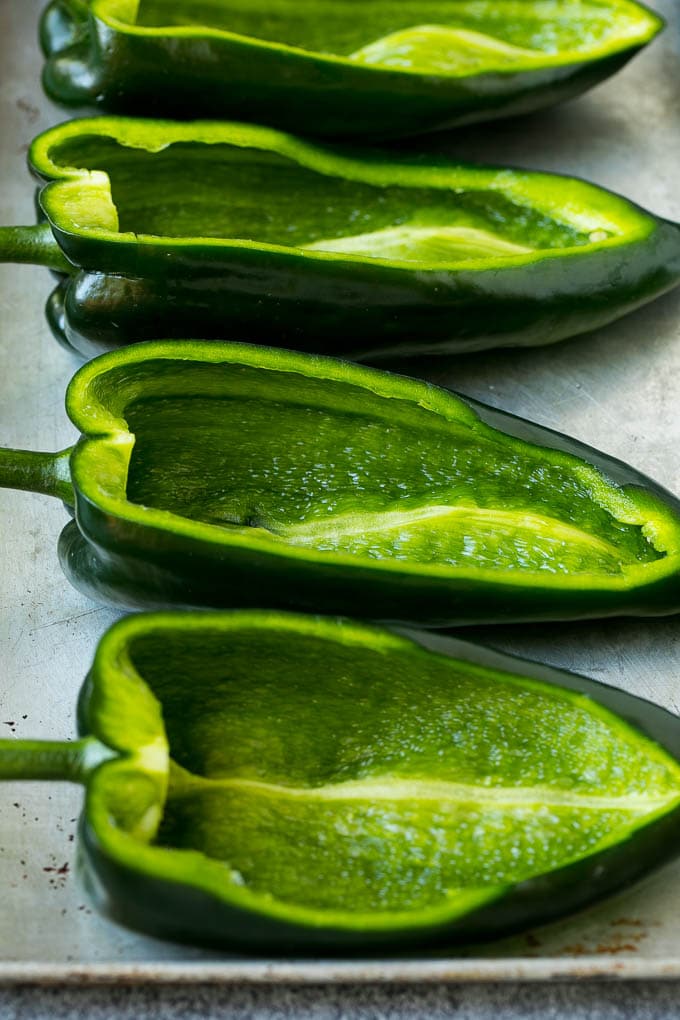 Stuffed Poblano Peppers | Stuffed Peppers | Pasilla Peppers #peppers #stuffedpeppers #beef #rice #beans #corn #dinner #jonep Hollowed out poblano peppers on a pan.