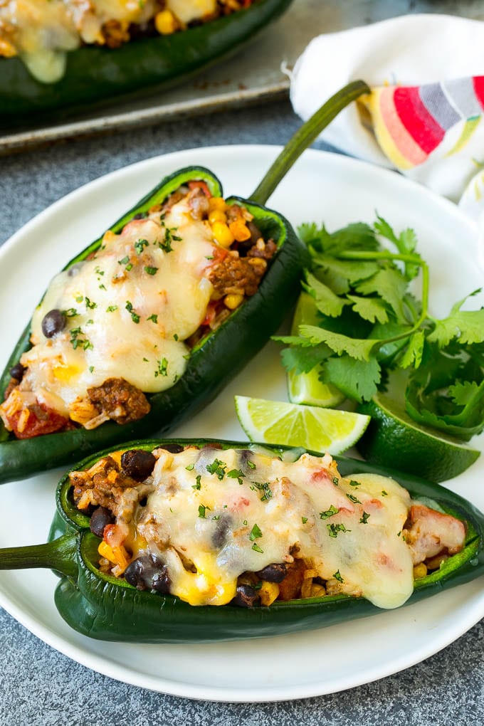 Stuffed Poblano Peppers | Stuffed Peppers | Pasilla Peppers #peppers #stuffedpeppers #beef #rice #beans #corn #dinner #jonep A plate of stuffed poblano peppers topped with melted cheese.