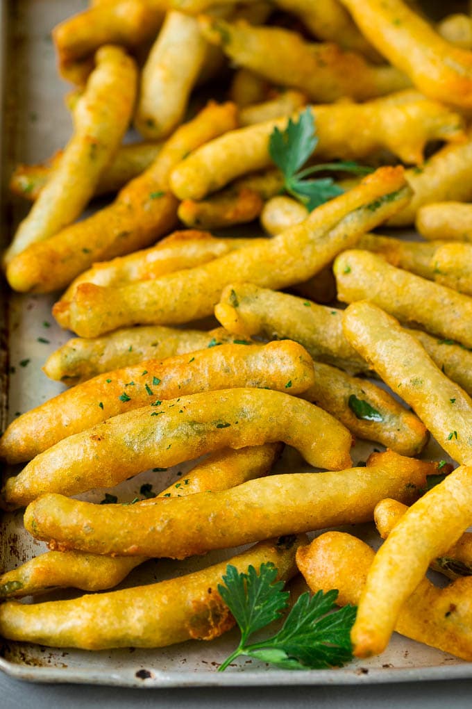 Fried Green Beans Recipe | Green Beans #greenbeans #appetizer #snack #jonep A sheet pan of fried green beans garnished with chopped parsley.