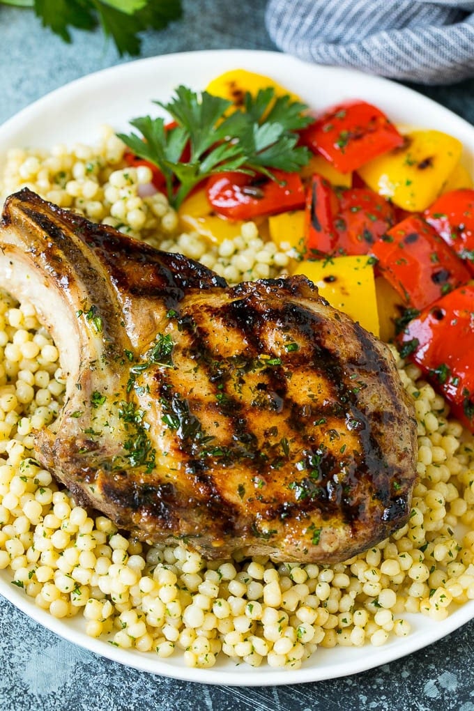 Grilled Pork Chops | Pork Chop Marinade #porkchops #grilling #pork #marinade #dinner #jonep A grilled pork chop served over couscous with bell peppers on the side.