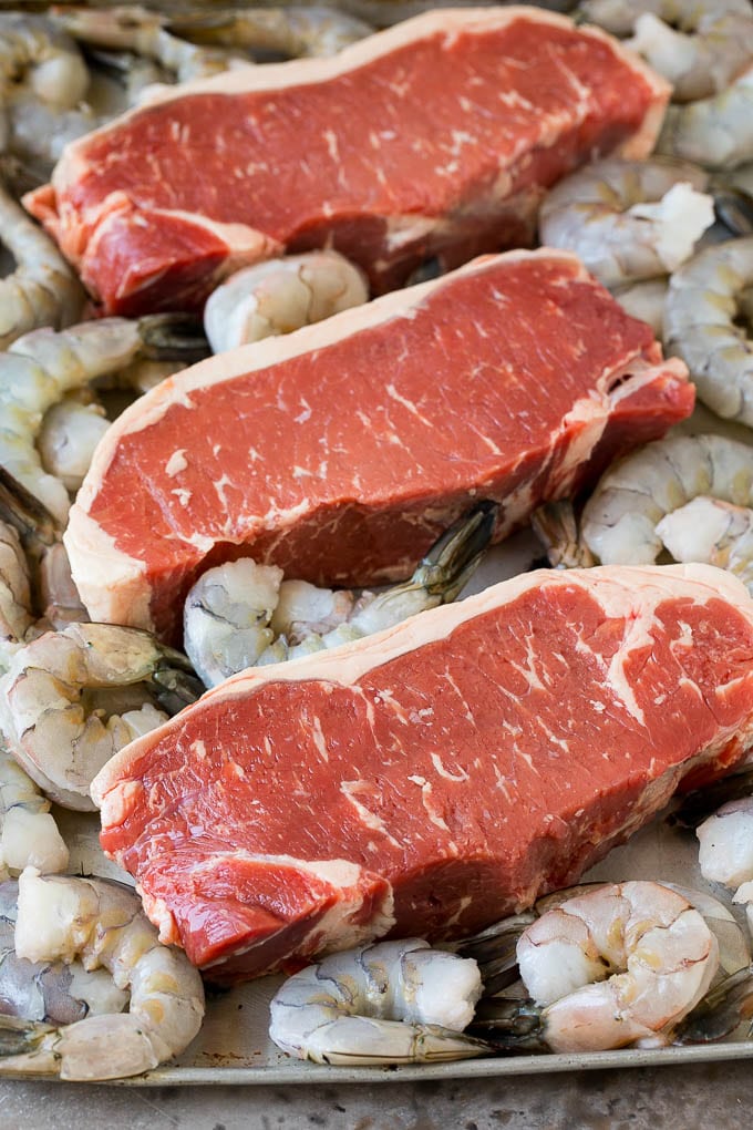 Surf and Turf Recipe | Seared Steak #steak #shrimp #keto #lowcarb #dinner #jonep Raw steaks and shrimp on a sheet pan.