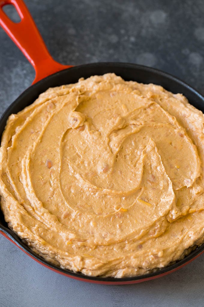 Bean Dip Recipe | Mexican Dip #dip #appetizer #mexicanfood #beans #cheese #jonep Refried frijoles mixed with cream cheese, sour cream and seasonings in a skillet.