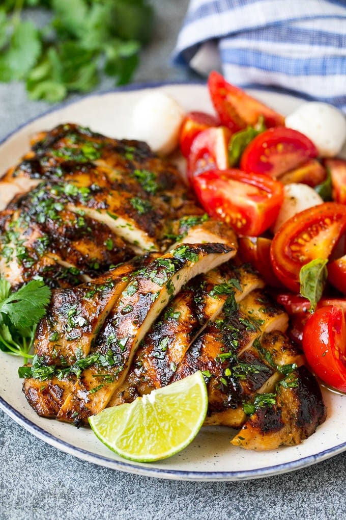 Sliced chicken thighs served with tomato salad.