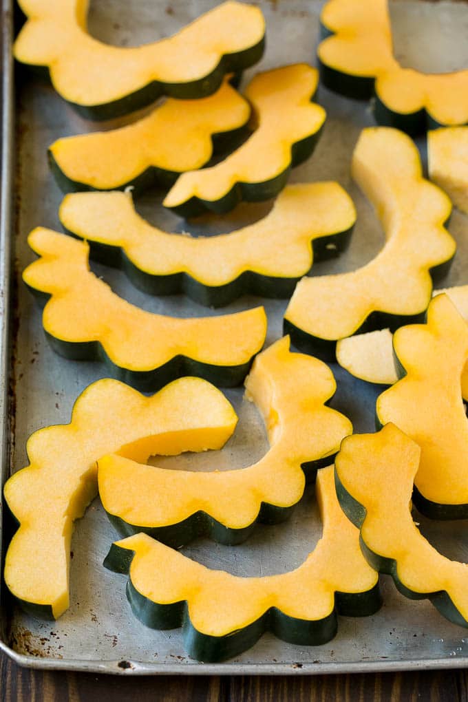 Roasted Acorn Squash | Acorn Squash Recipe #squash #winter #sidedish #dinner #jonep Sliced acorn squash on a sheet pan.