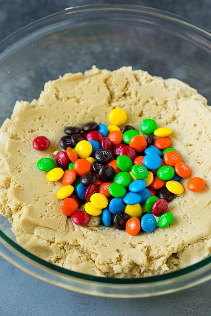 M&M Cookies Recipe #cookies #chocolate #baking #dessert #sweets #jonep A bowl of cookie dough with chocolate candies in it.