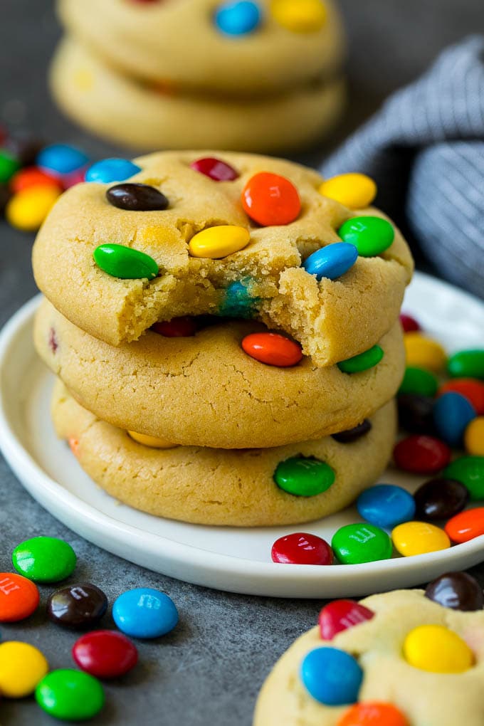 M&M Cookies Recipe #cookies #chocolate #baking #dessert #sweets #jonep A stack of M&M cookies with a bite taken out of one.