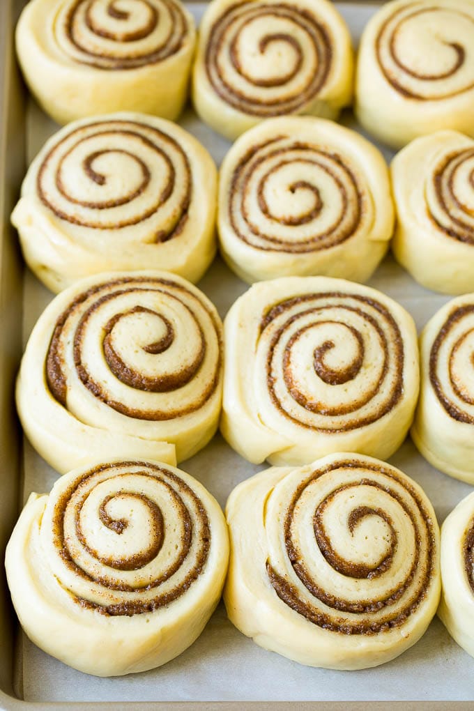 Cinnamon Rolls Recipe | Cinnamon Buns #cinnamon #rolls #pastry #breakfast #brunch #sweets #jonep #baking #bread Rolls of dough and filling rising on a sheet pan.
