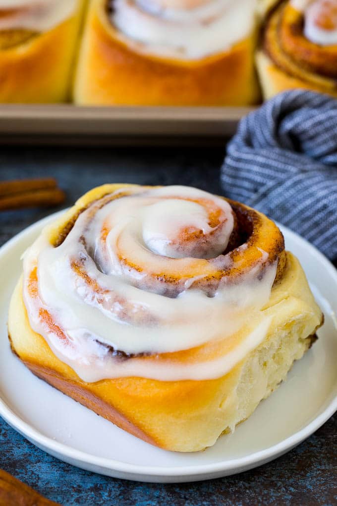 Cinnamon Rolls Recipe | Cinnamon Buns #cinnamon #rolls #pastry #breakfast #brunch #sweets #jonep #baking #bread A frosted cinnamon bun on a serving plate.