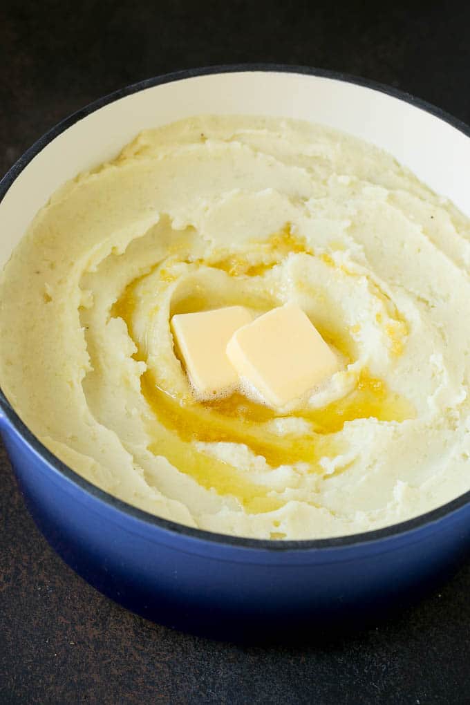 Garlic Mashed Potatoes Recipe #garlic #potatoes #mashedpotatoes #sidedish #dinner #thanksgiving #jonep Spuds with melted butter on top.