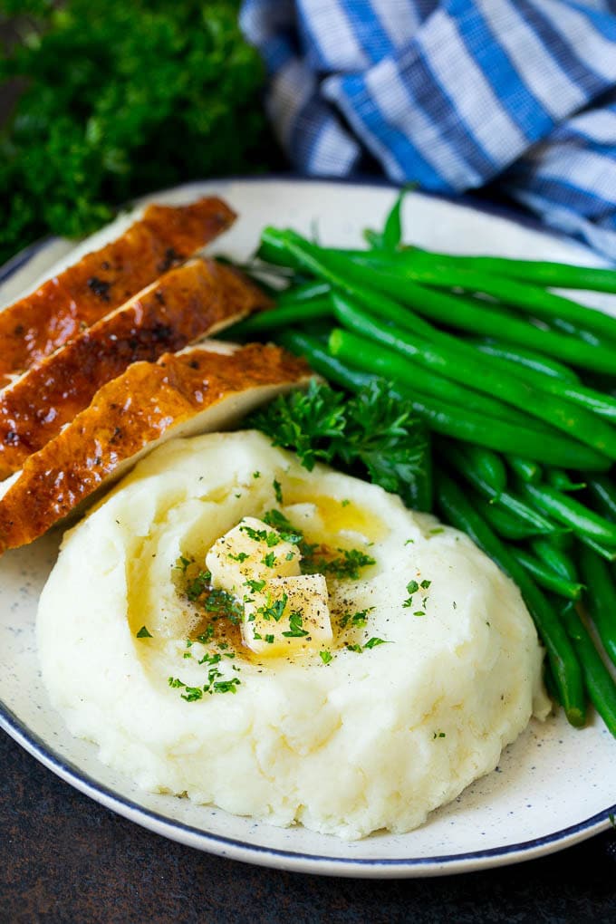 Garlic Mashed Potatoes Recipe #garlic #potatoes #mashedpotatoes #sidedish #dinner #thanksgiving #jonep A plate with garlic mashed potatoes, green beans and sliced turkey.