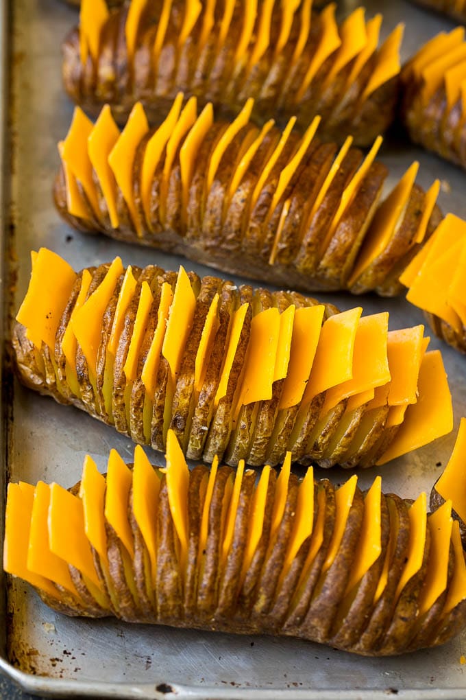 Hasselback Potatoes Recipe #potatoes #bacon #sidedish #cheese #dinner #jonep Thinly sliced potatoes with slices of cheese in between the cuts.