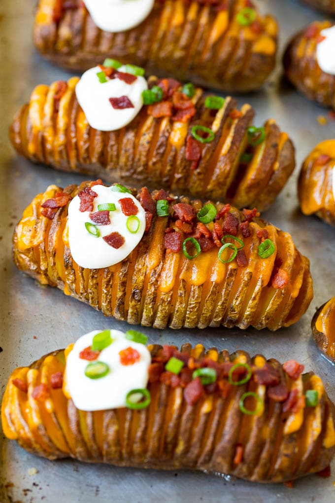 Hasselback Potatoes Recipe #potatoes #bacon #sidedish #cheese #dinner #jonep Hasselback potatoes filled with melted cheese, then topped with bacon, sour cream and green onions.