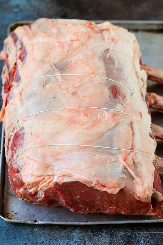 Prime Rib Recipe #primerib #beef #roast #dinner #thanksgiving #christmas #keto #lowcarb #jonep A tied standing rib roast on a sheet pan.