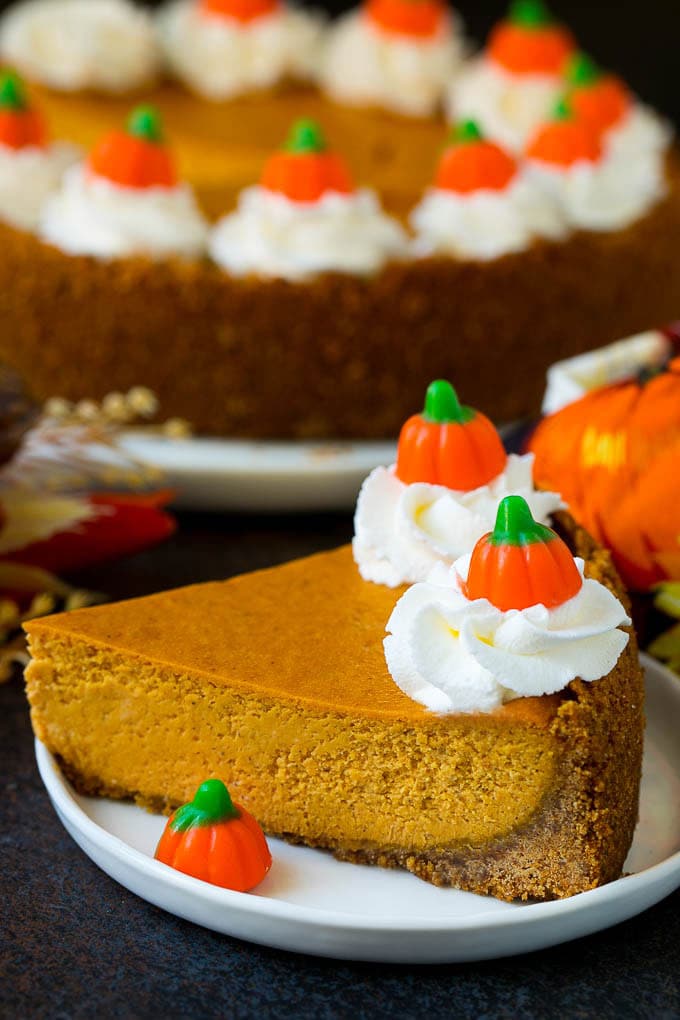 Pumpkin Pie Cheesecake Recipe | Pumpkin Cheesecake #cake #cheesecake #pumpkin #fall #thanksgiving #dessert #jonep A slice of pumpkin pie cheesecake garnished with whipped cream.