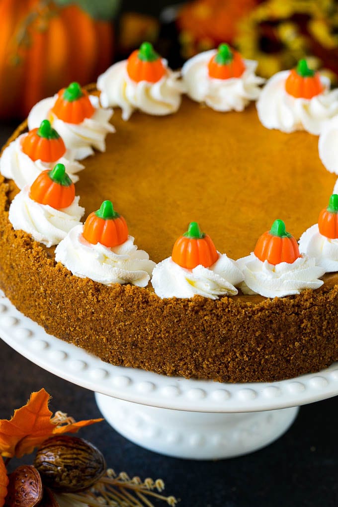 Pumpkin Pie Cheesecake Recipe | Pumpkin Cheesecake #cake #cheesecake #pumpkin #fall #thanksgiving #dessert #jonep Pumpkin pie cheesecake topped with whipped cream and candy pumpkins.
