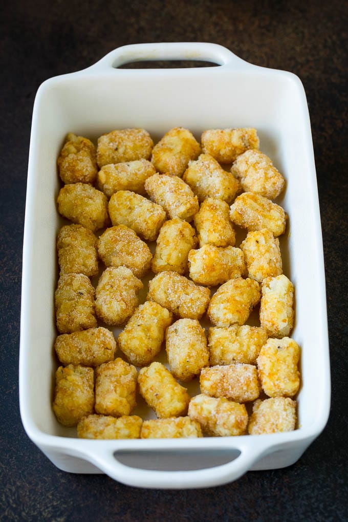 Sausage Egg Casserole Recipe | Egg Casserole #eggs #sausage #potato #cheese #casserole #breakfast #brunch #jonep Potato tots in a casserole dish.