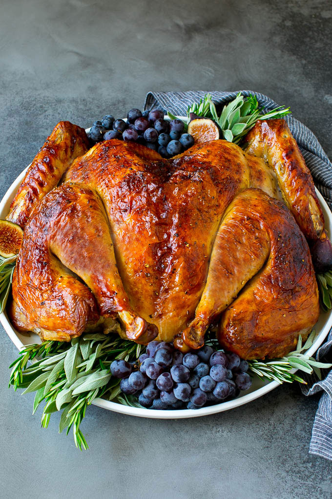 Spatchcock Turkey | Roasted Turkey | Thanksgiving Turkey #turkey #thanksgiving #dinner #fall #christmas #jonep Spatchcock turkey garnished with grapes and fresh herbs.