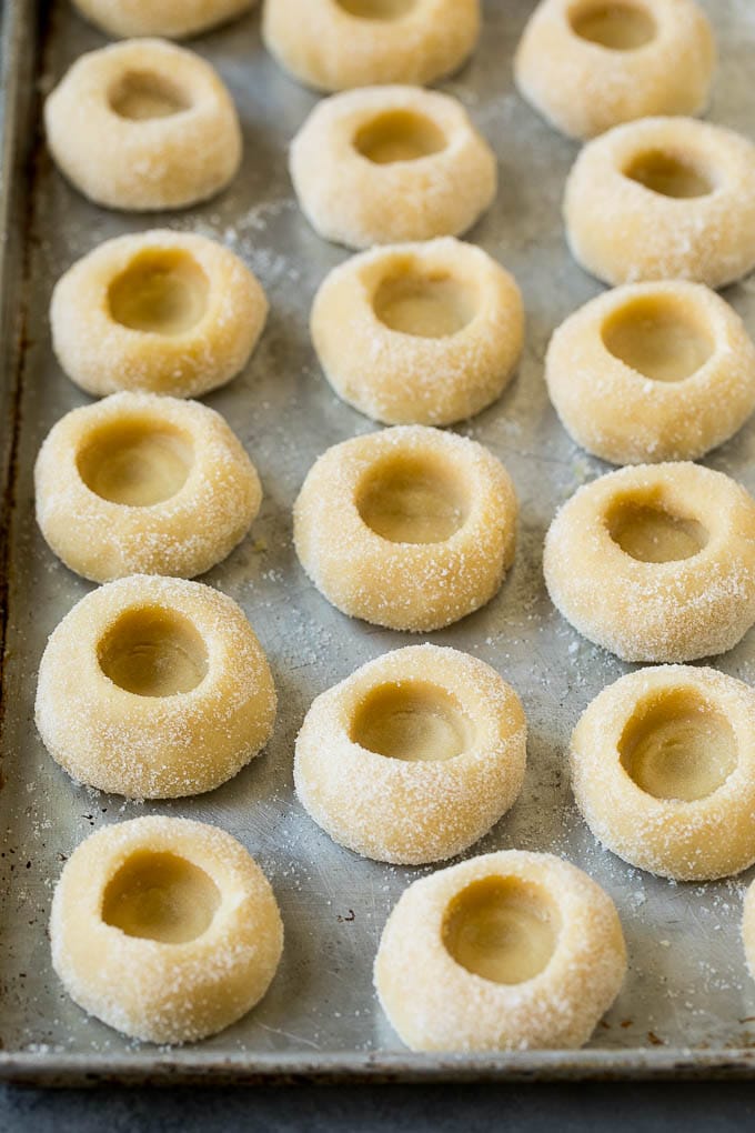Thumbprint Cookies | Sugar Cookies #cookies #baking #christmas #dessert #jonep Balls of cookie dough with indentations in them.