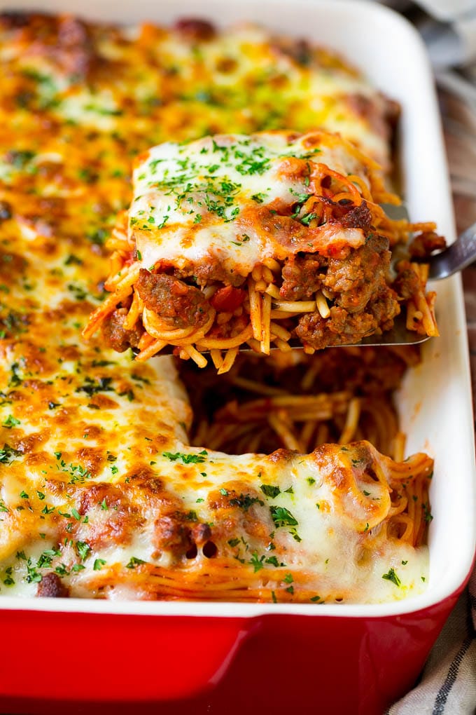 Baked Spaghetti Recipe | Baked Pasta #spaghetti #pasta #cheese #casserole #beef #sausage #dinner #jonep A spatula holding up a serving of baked spaghetti.