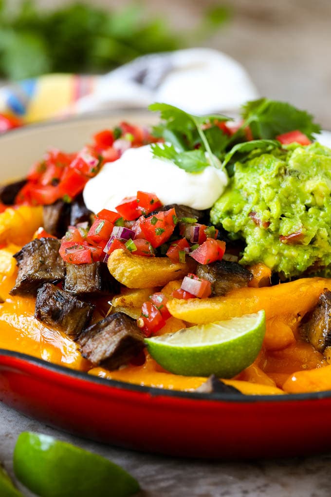 Carne Asada Fries Recipe | Steak Fries #fries #frenchfries #steak #salsa #avocado #cheese #dinner #appetizer #jonep Carne asada fries in a skillet topped with sour cream, pico de gallo and steak.