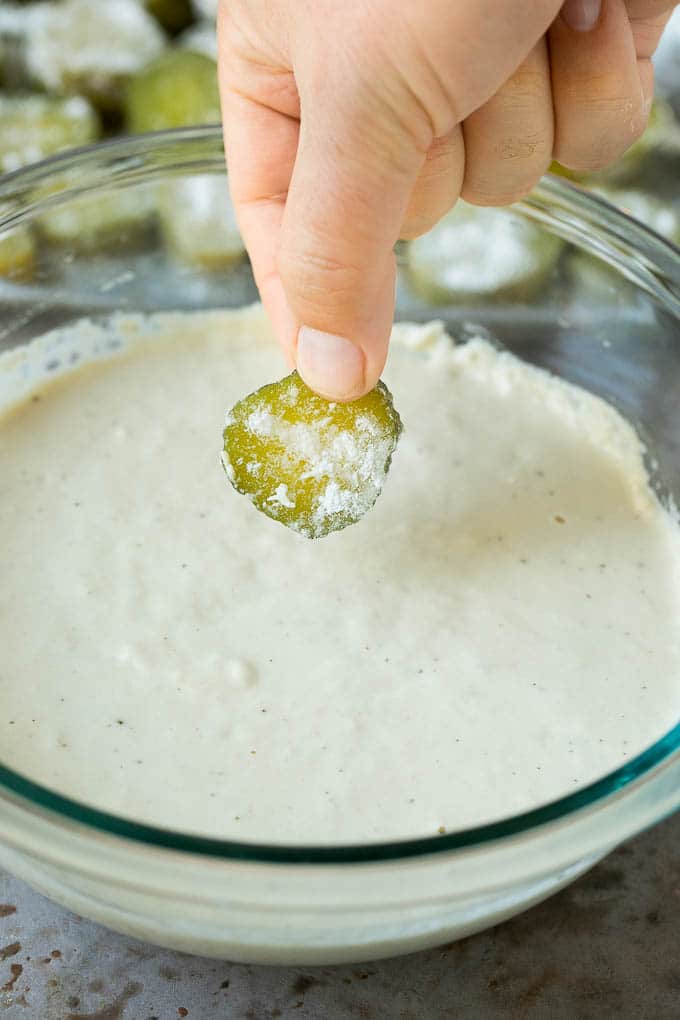 Fried Pickles Recipe #pickles #appetizer #snack #jonep A slice being dipped into a bowl of beer batter.