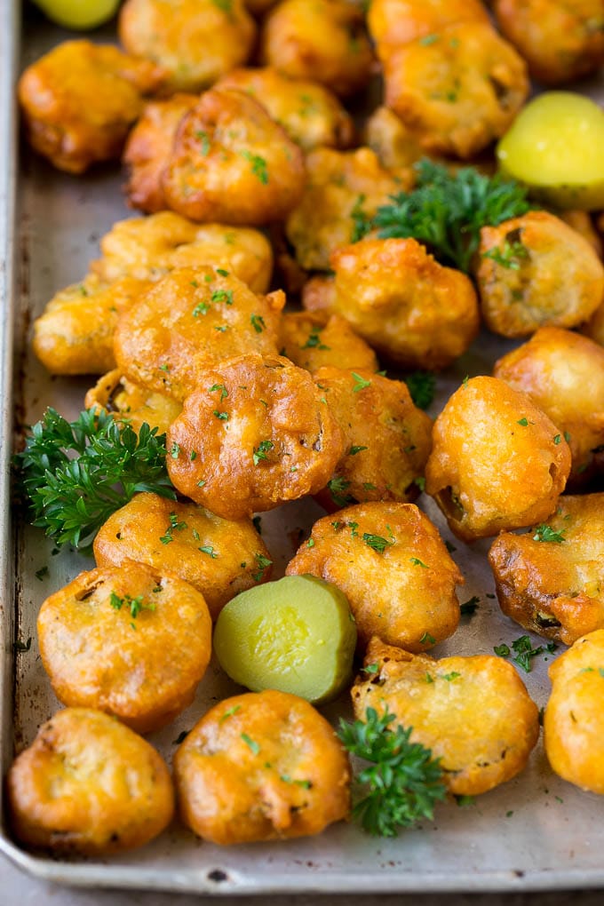 Fried Pickles Recipe #pickles #appetizer #snack #jonep Fried pickles on a sheet pan, garnished with parsley.