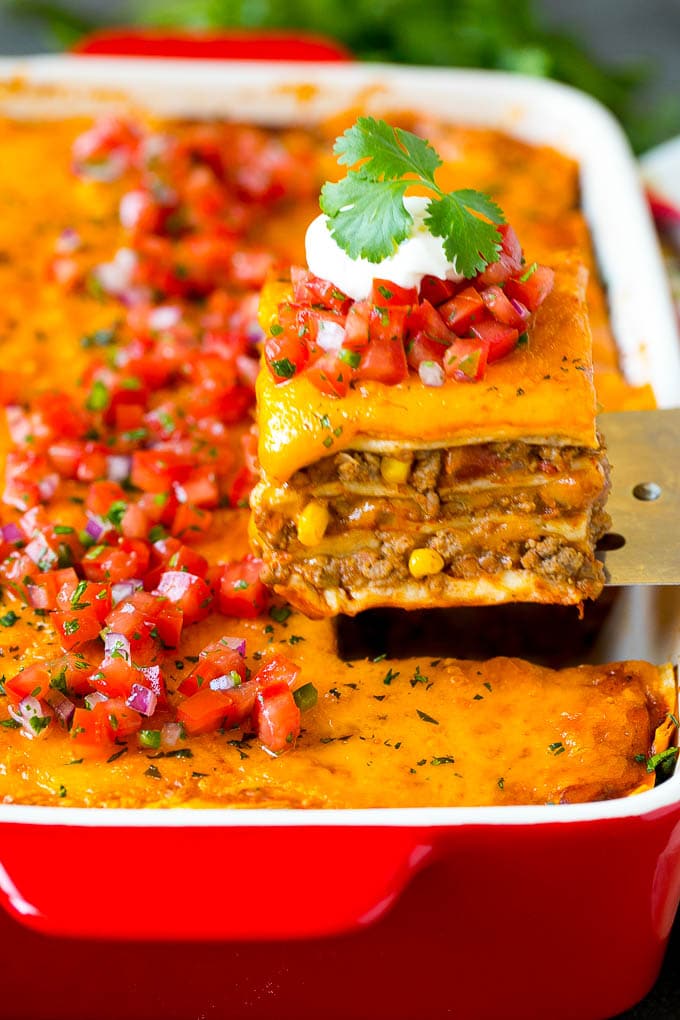 Mexican Lasagna Recipe | Mexican Casserole #mexican #lasagna #groundbeef #beans #dinner #cheese #jonep A spatula serving up a portion of Mexican lasagna.