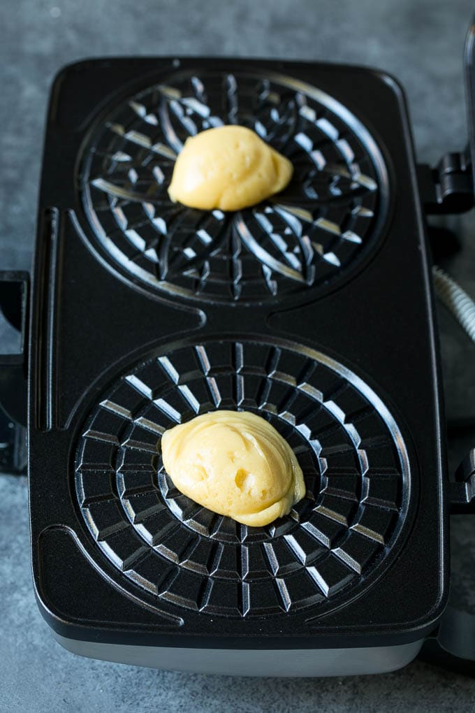 Pizzelle Cookies Recipe #cookies #baking #dessert #christmas #jonep Dollops of dough in a cookie iron.