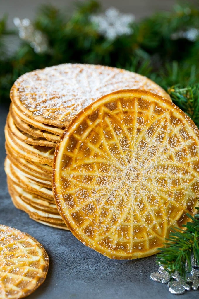 Pizzelle Cookies Recipe #cookies #baking #dessert #christmas #jonep A stack of pizzelle cookies dusted with powdered sugar.