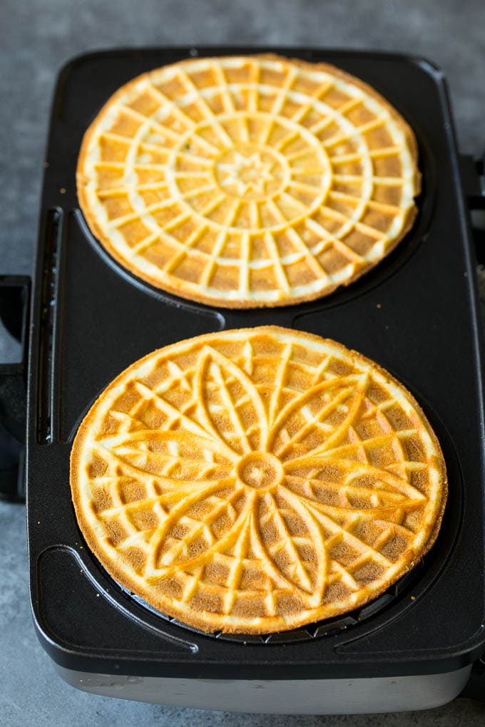 Pizzelle Cookies Recipe #cookies #baking #dessert #christmas #jonep Baked cookies inside a pizzelle iron.