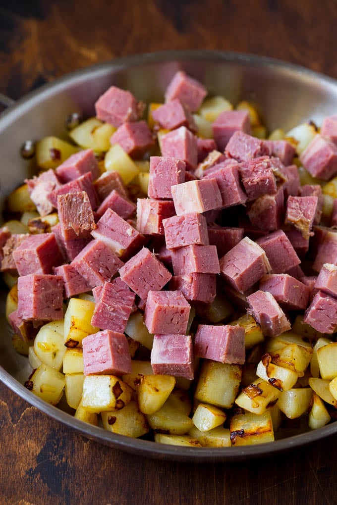 Corned Beef Hash Recipe #hash #cornedbeef #stpatricksday #breakfast #brunch #potatoes #jonep Cubed corn beef on top of cooked potatoes.