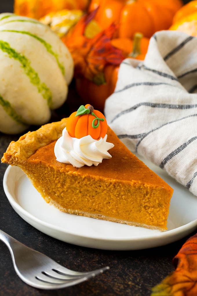 Homemade Pumpkin Pie Recipe | Pumpkin Pie #pie #pumpkin #baking #thanksgiving #fall #dessert #jonep A slice of homemade pumpkin pie topped with whipped cream and a candy pumpkin.