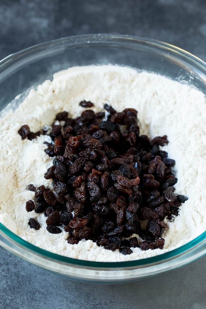Irish Soda Bread Recipe #bread #baking #stpatricksday #sidedish #jonep Flour, sugar, butter, baking powder and raisins in a mixing bowl.