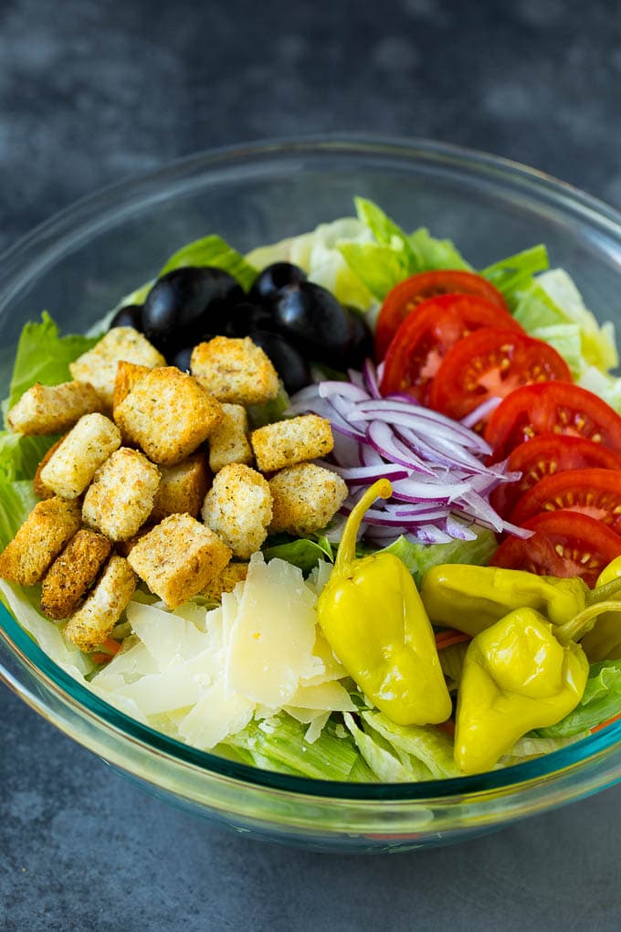 Olive Garden Salad Recipe | Italian Salad #salad #lettuce #olives #sidedish #dinner #jonep Lettuce, vegetables, olives and croutons in a bowl.